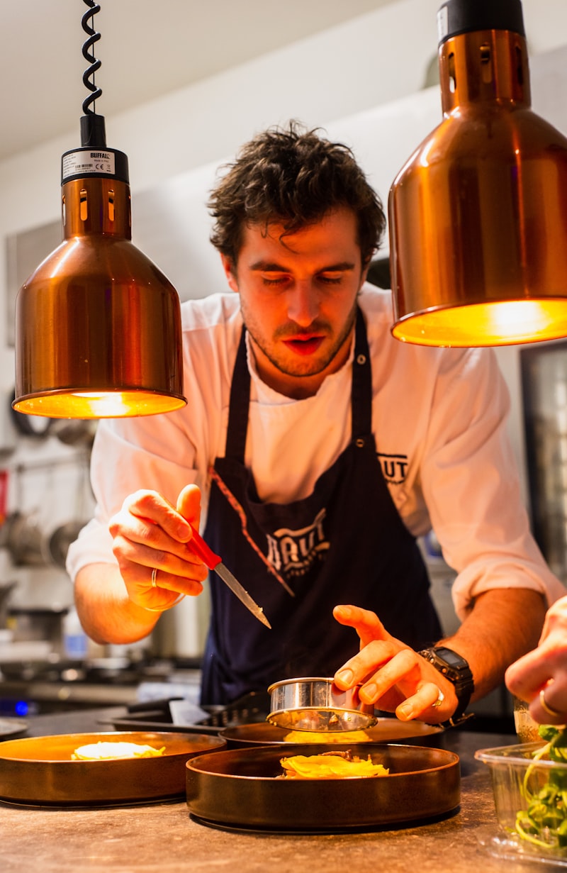 A line cook plating a dish during service